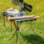 TakTable set up outside with telescoping edge braces holding a miter saw