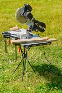 TakTable set up outside with telescoping edge braces holding a miter saw