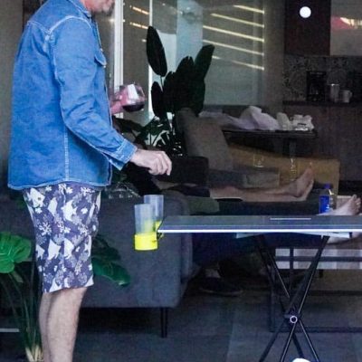A grown man playing beer pong on taktables